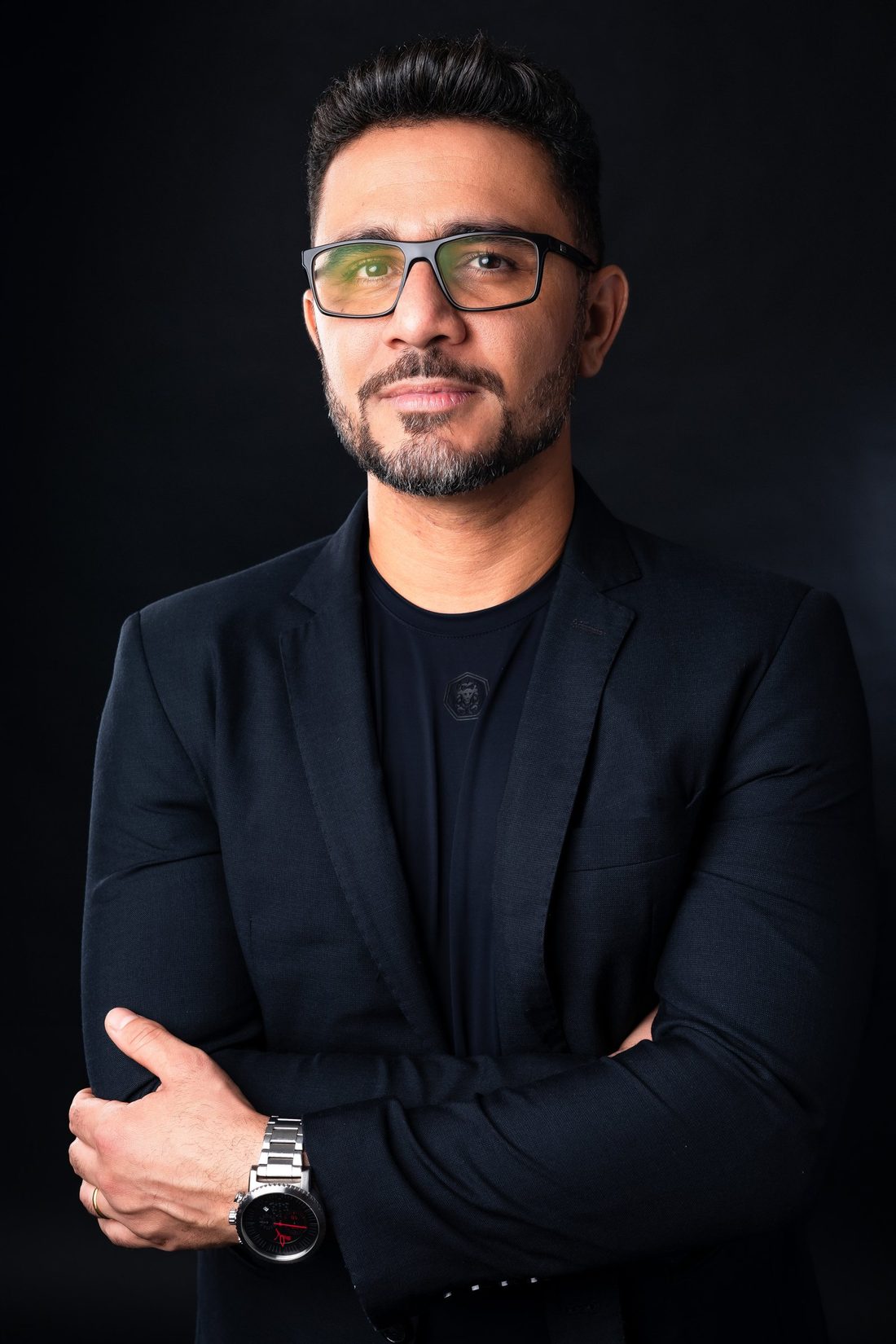 Adeilton Rufino de blazer preto, de braços cruzados